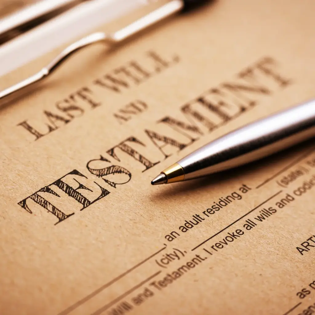 A pen sits on a last will and testament document