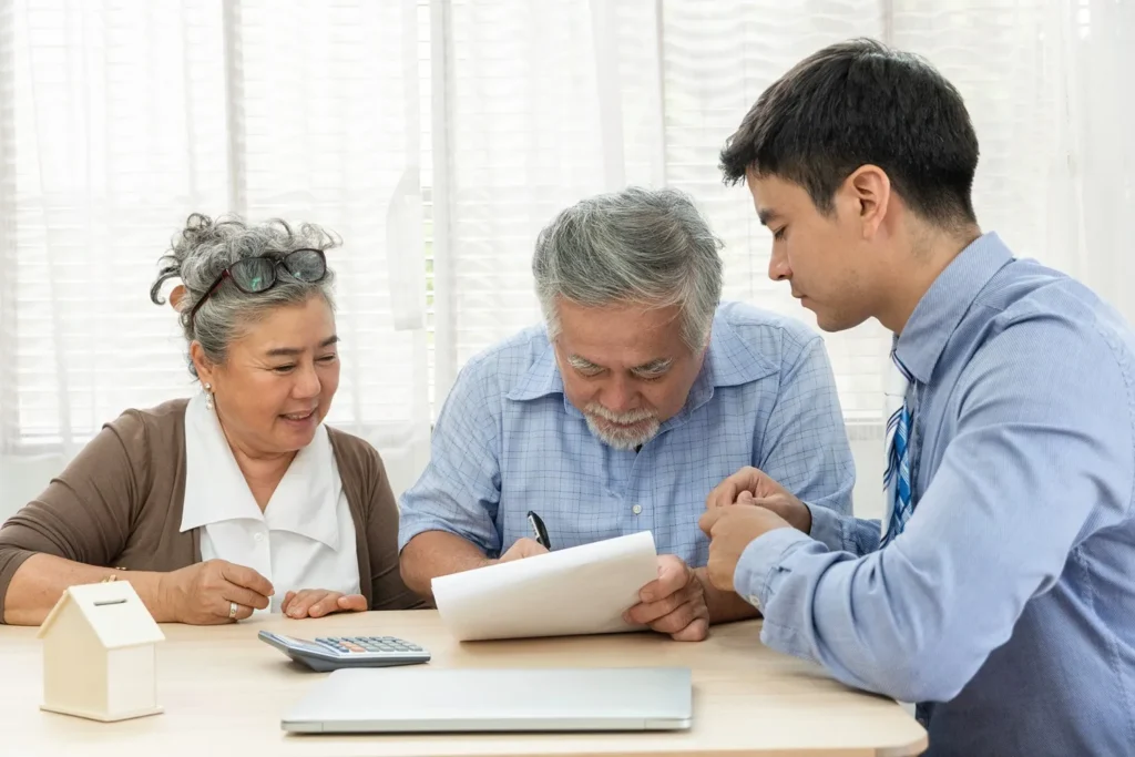 An elderly couple signing estate paperwork.