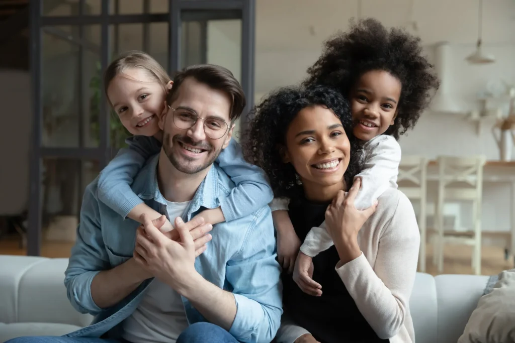 A family of four smiling and posing.